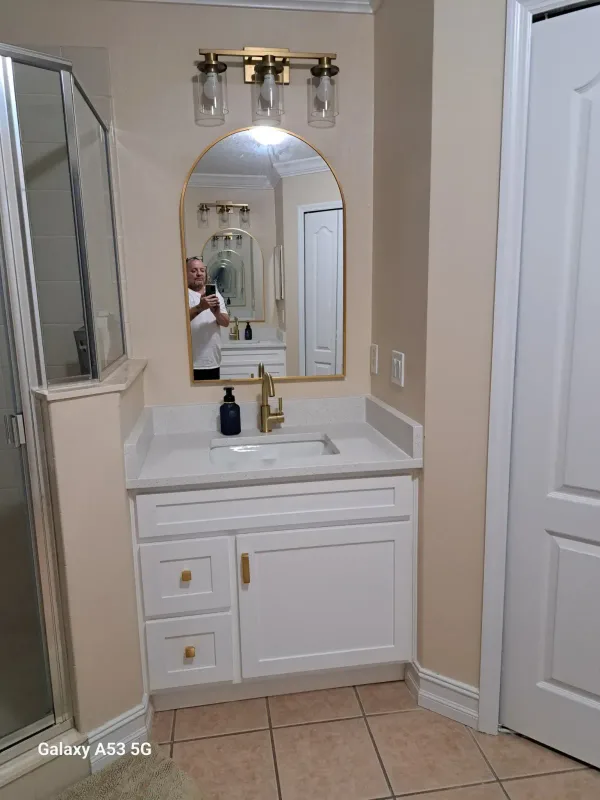 Bathroom vanity install with mirror, light fixture, sink fixture and cabinet handles — after